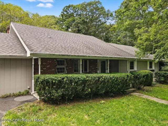 a view of a house with backyard and a tree