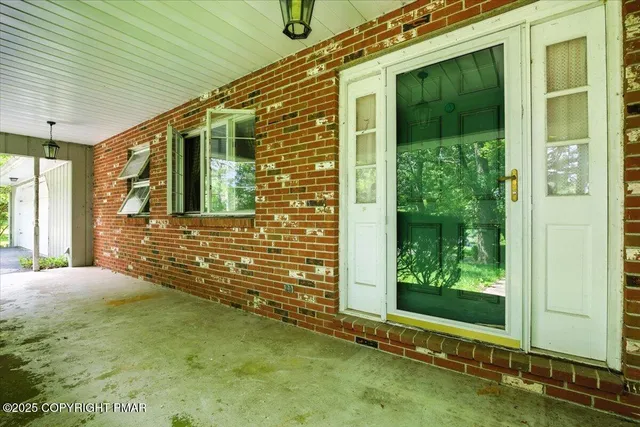 an empty room with windows and fireplace