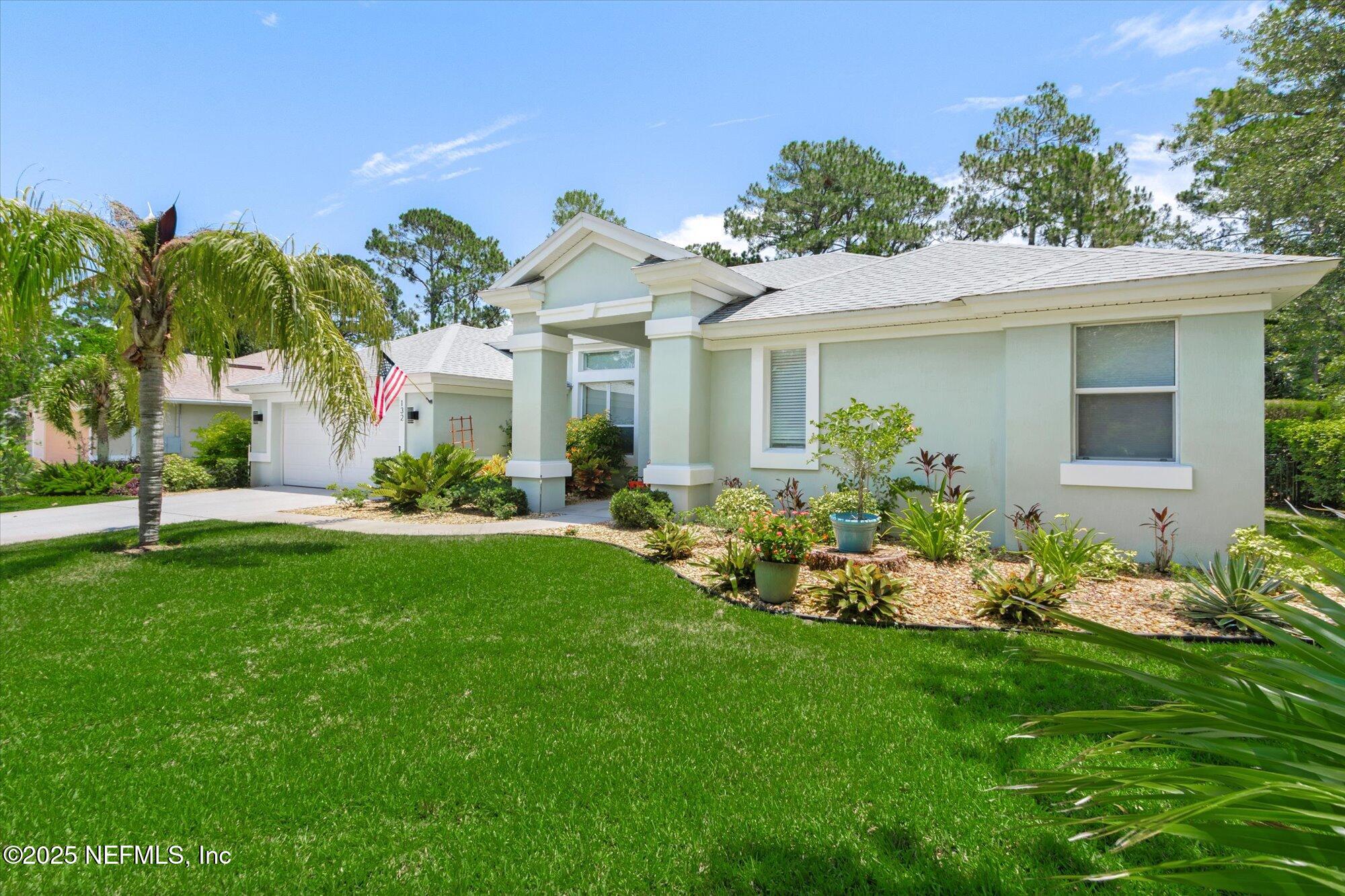 132 Bottlebrush Drive St. Augustine, FL 32086 - Photo 1 of 56 a front view of a house with a garden and plants
