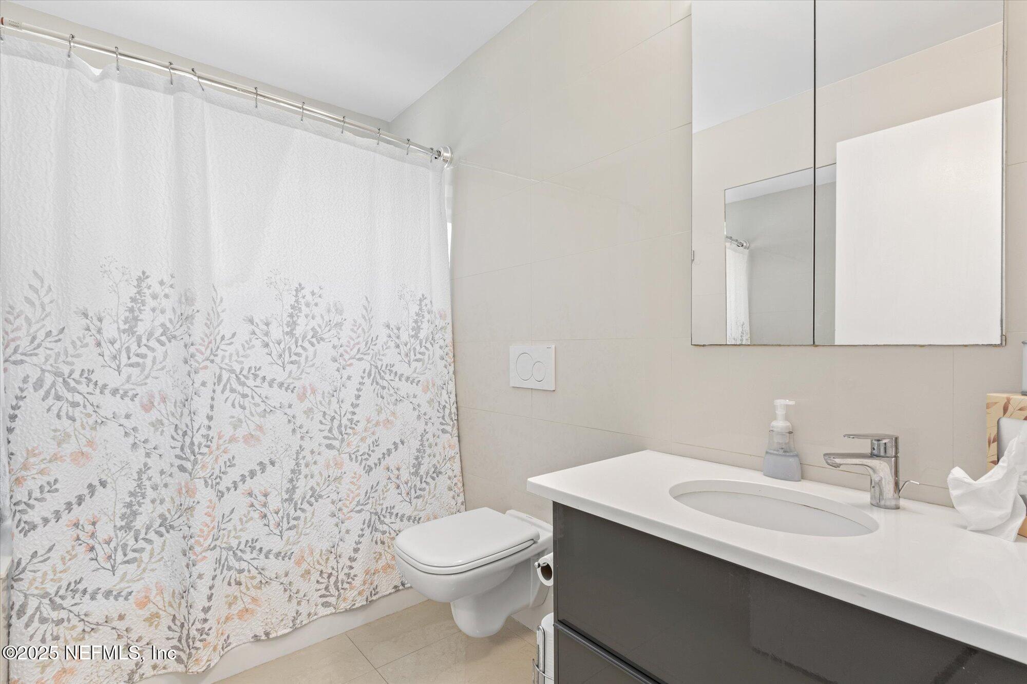 132 Bottlebrush Drive St. Augustine, FL 32086 - Photo 19 of 56 a bathroom with a sink a toilet and shower curtain