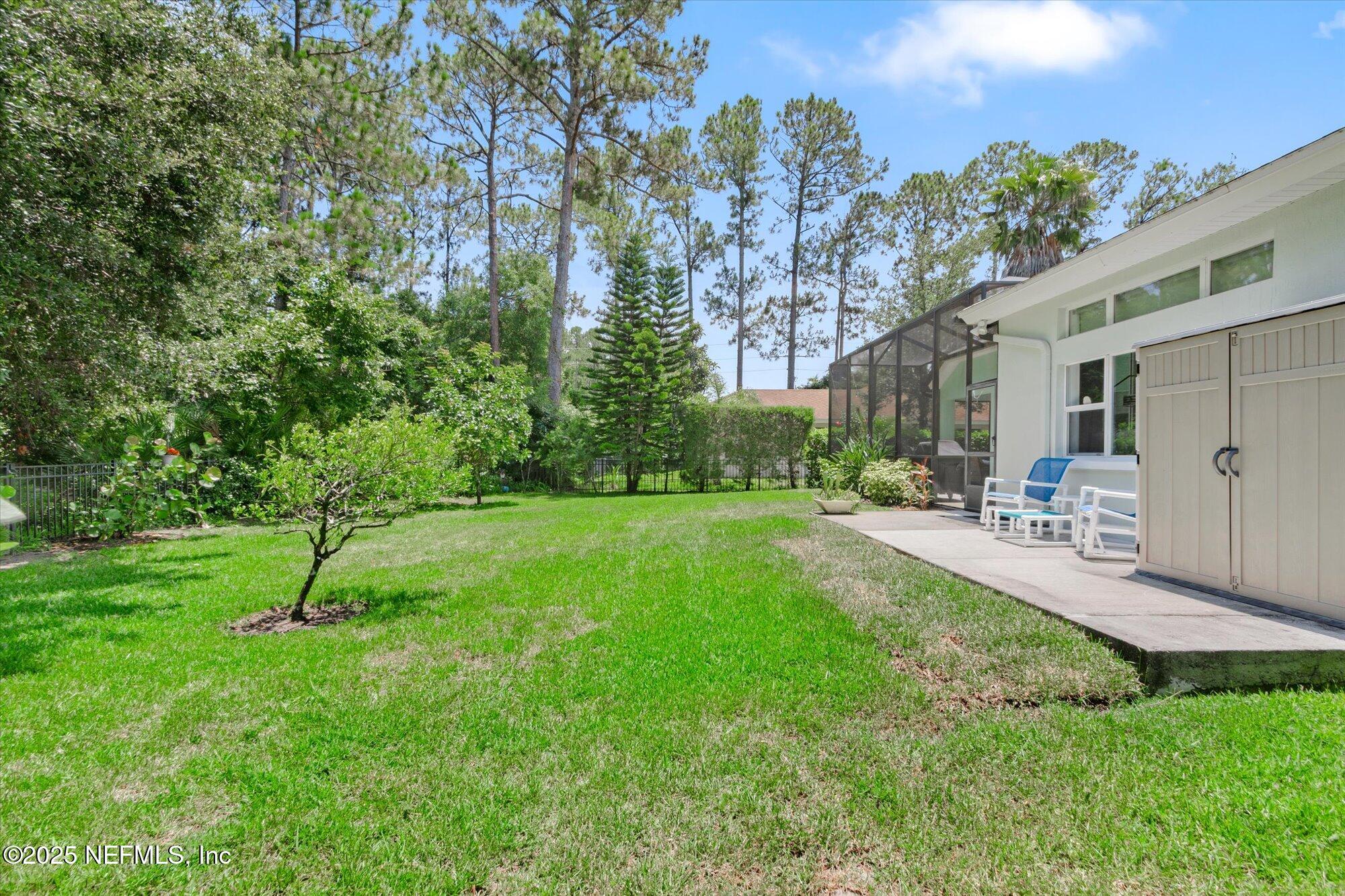 132 Bottlebrush Drive St. Augustine, FL 32086 - Photo 37 of 56 a view of a backyard with table and chairs and wooden fence