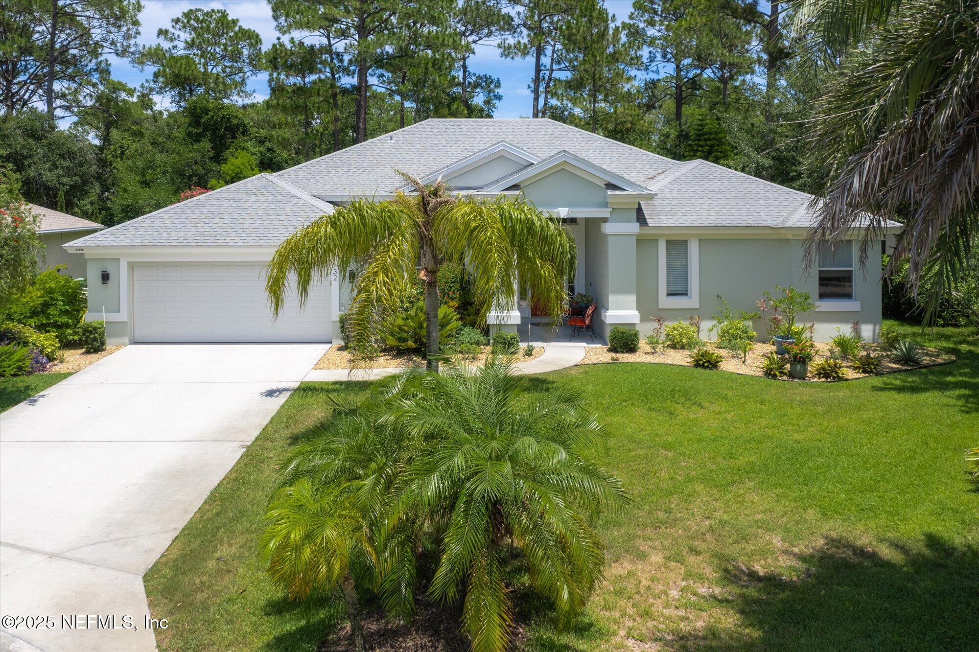 132 Bottlebrush Drive St. Augustine, FL 32086 - Photo 42 of 56 a view of a patio with table and chairs under an umbrella