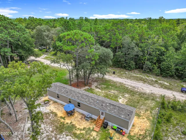 an aerial view of a house with a yard and lake view
