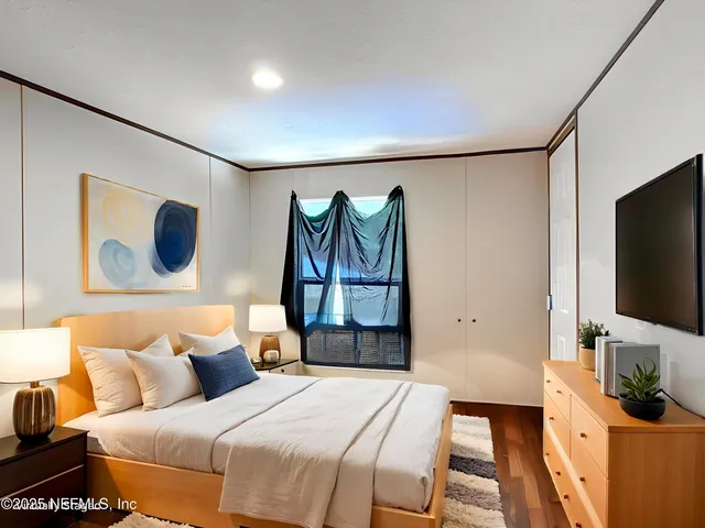 a bedroom with a bed and a flat screen tv