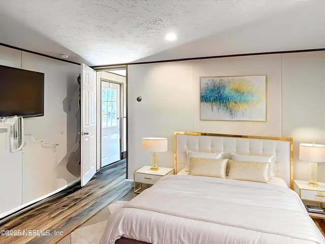 a bedroom with a bed and wooden floor