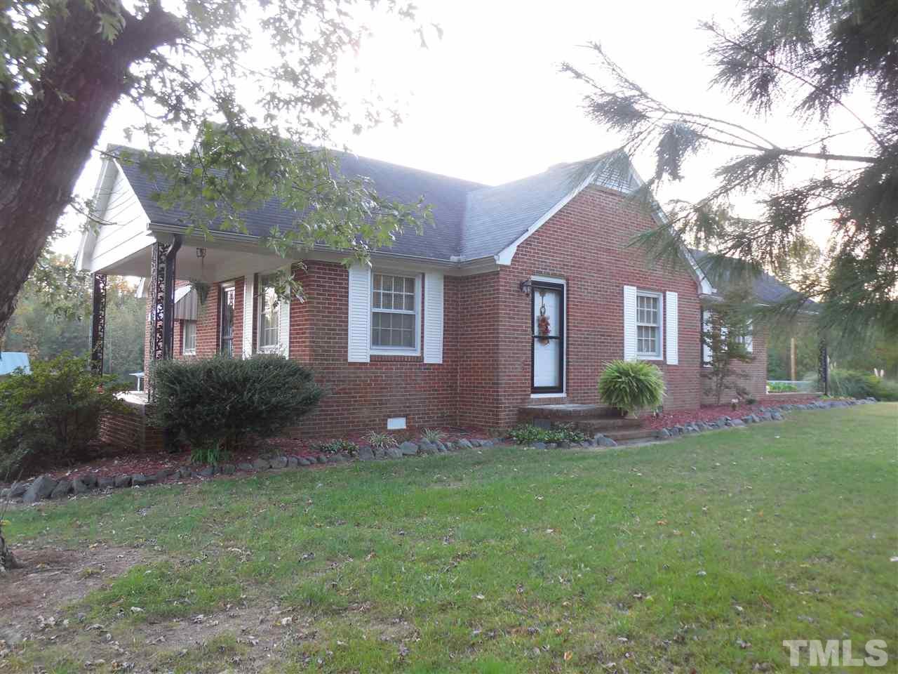 2150 Sanders Road Stem, NC 27581 - Photo 2 of 13 a front view of a house with a yard and garage