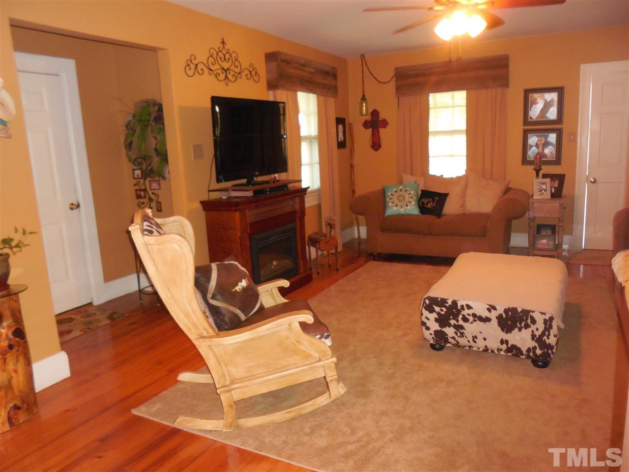 2150 Sanders Road Stem, NC 27581 - Photo 8 of 13 a living room with furniture a flat screen tv and a window