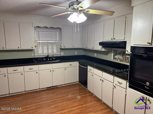a kitchen with granite countertop a sink stainless steel appliances and cabinets