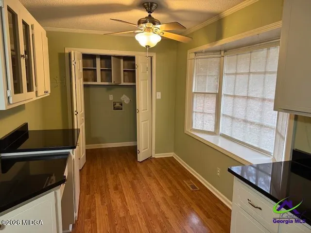a view of a livingroom with wooden floor and a ceiling fan