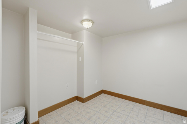 378 West 200 South Bountiful, UT 84010 - Photo 25 of 32 Room featuring light-toned walls, a built-in clothing rod, wood-finish baseboards, and a semi-flush mount ceiling light