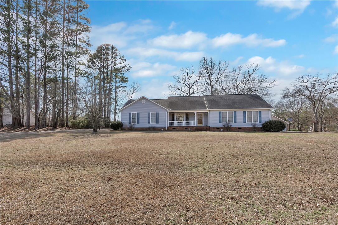 This ranch-style home features a classic front porch, perfect for enjoying peaceful surroundings.
