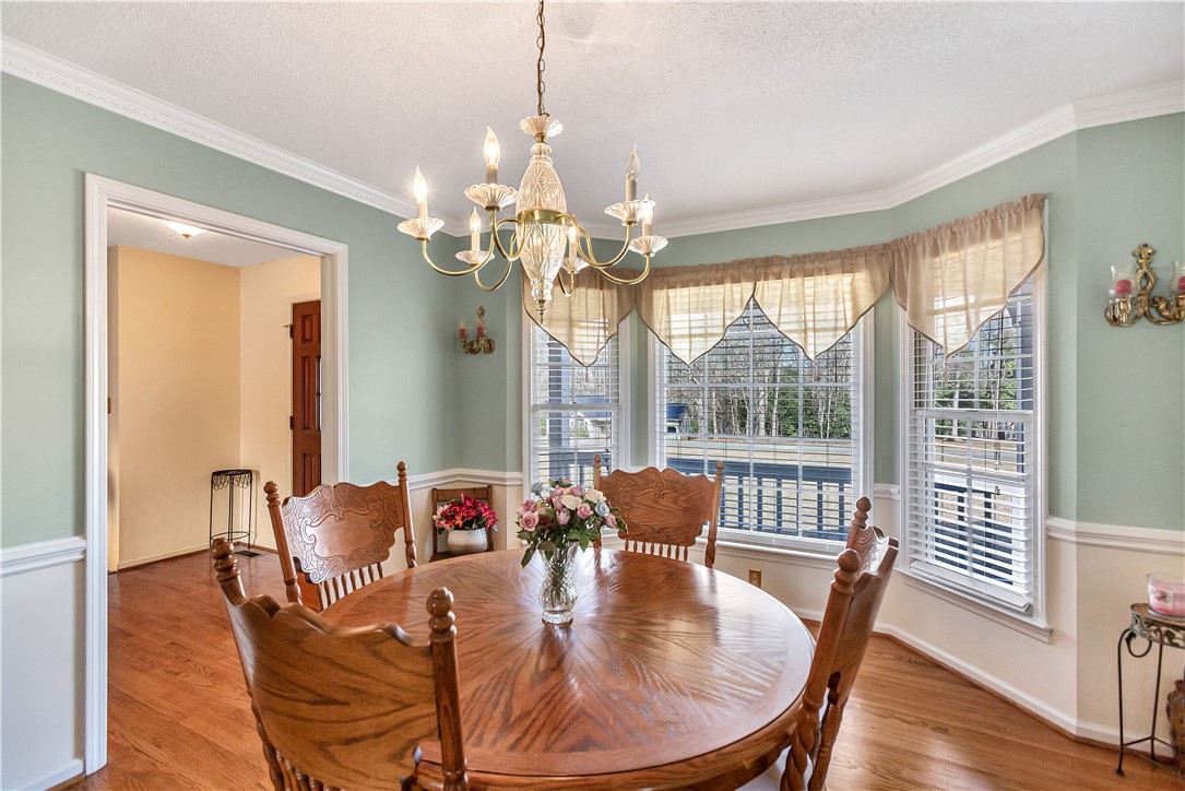 1116 Green Willow Trail Anderson, SC 29621 - Photo 16 of 45 This bright dining room features a decorative chandelier and hardwood flooring, perfect for gatherings.