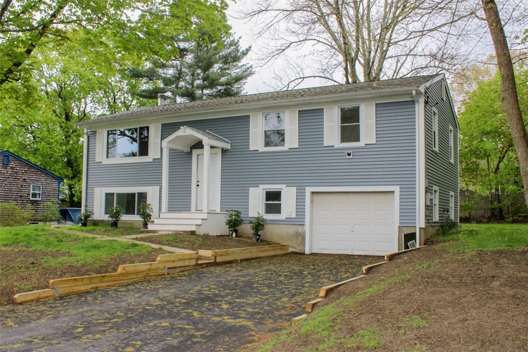 Exterior front. Located in Lovely Laurel Park, this beautifully renovated Raised Ranch sits on a quiet corner above the Kickemuit River - no flood needed! Recent yard work includes new retaining walls along the recently-paved driveway.