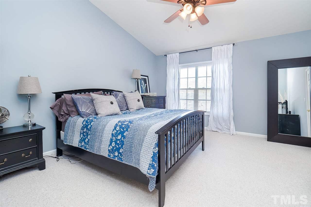 4714 Longhill Lane Raleigh, NC 27612 - Photo 9 of 19 a bedroom with a bed and a chandelier