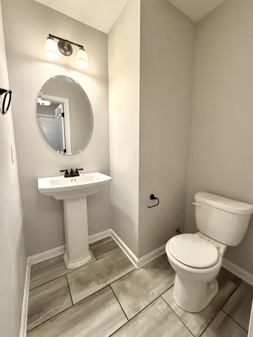 a bathroom with a sink toilet and mirror
