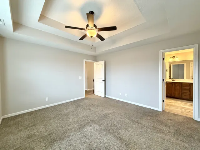 a view of a livingroom with a chandelier fan and a kitchen
