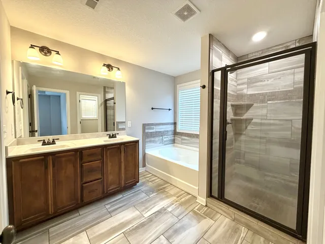a spacious bathroom with a shower sink and mirror