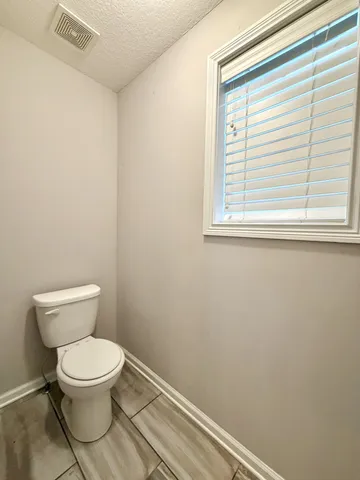 a white toilet sitting next to a window