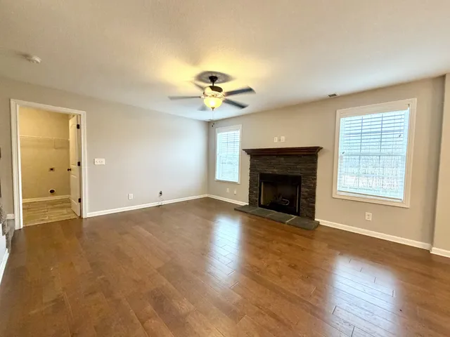 a view of an empty room with a fireplace and a window