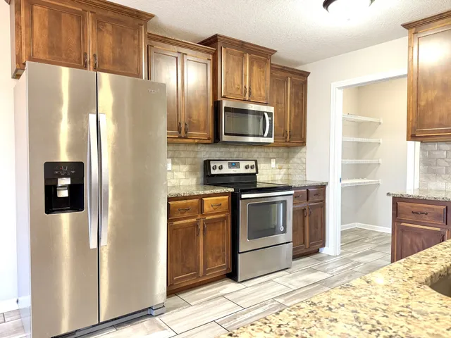 a kitchen with stainless steel appliances a refrigerator stove and microwave