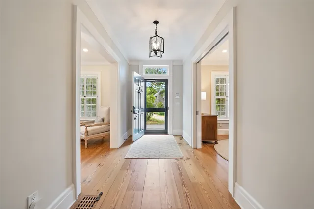 a view of a hallway with wooden floor and windows