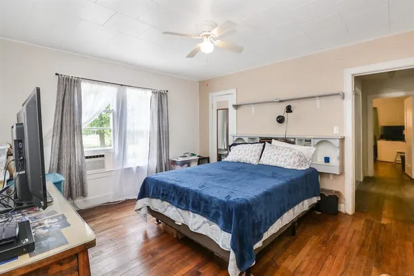 a bedroom with a bed and a flat tv screen on dresser