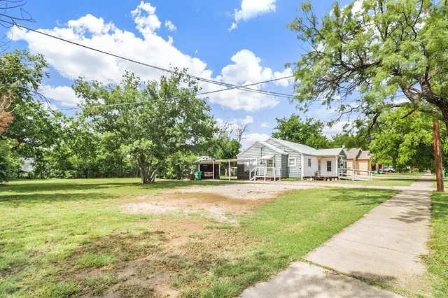 a front view of a house with a yard and trees