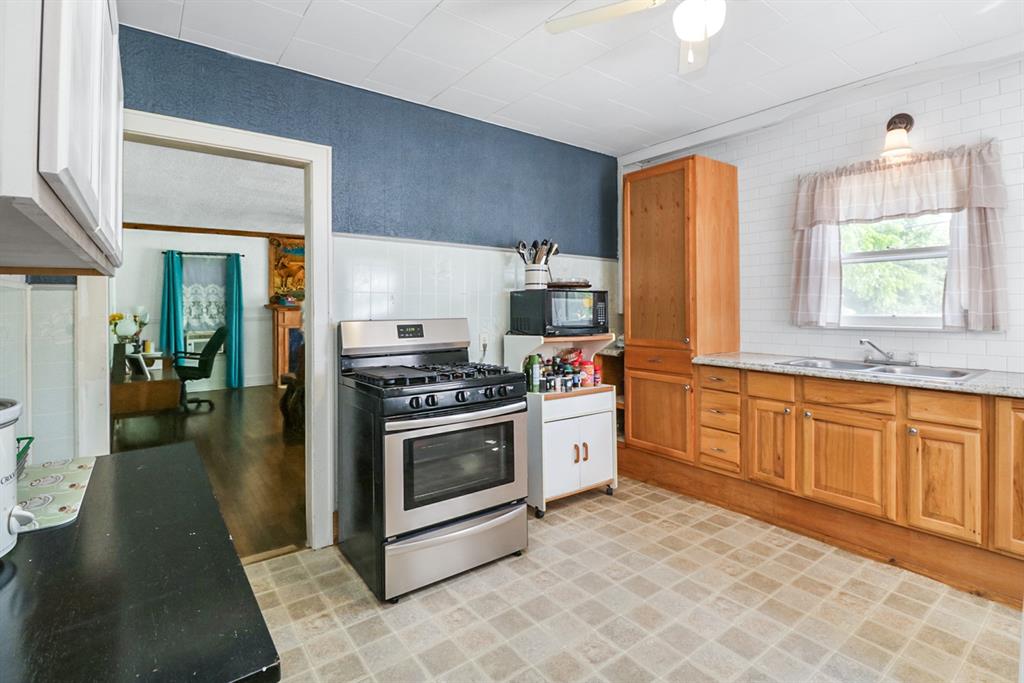605 West Walnut Street Coleman, TX 76834 - Photo 6 of 18 a kitchen with stainless steel appliances granite countertop a stove a sink and a refrigerator