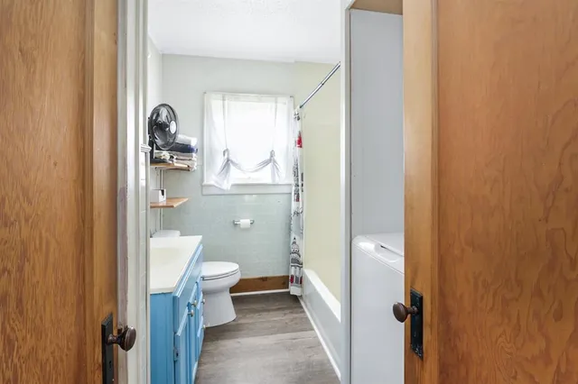 a bathroom with a granite countertop toilet and a sink