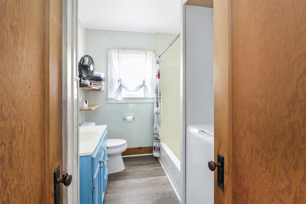 605 West Walnut Street Coleman, TX 76834 - Photo 9 of 18 a bathroom with a granite countertop toilet and a sink