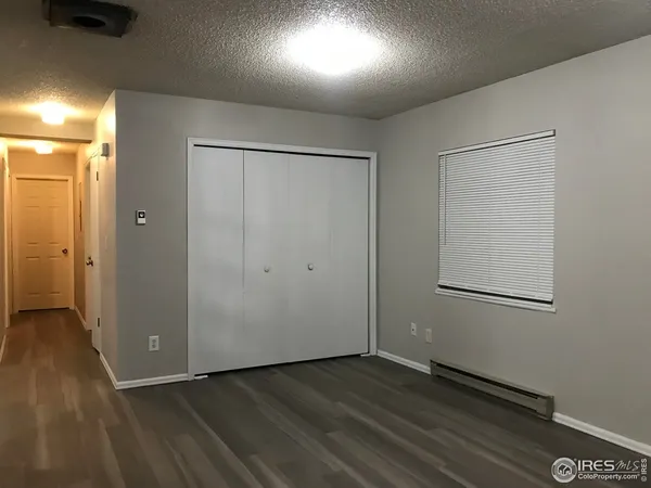 wooden floor in an empty room with a kitchen