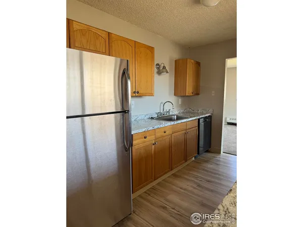 a kitchen with stainless steel appliances granite countertop a sink and wooden cabinets