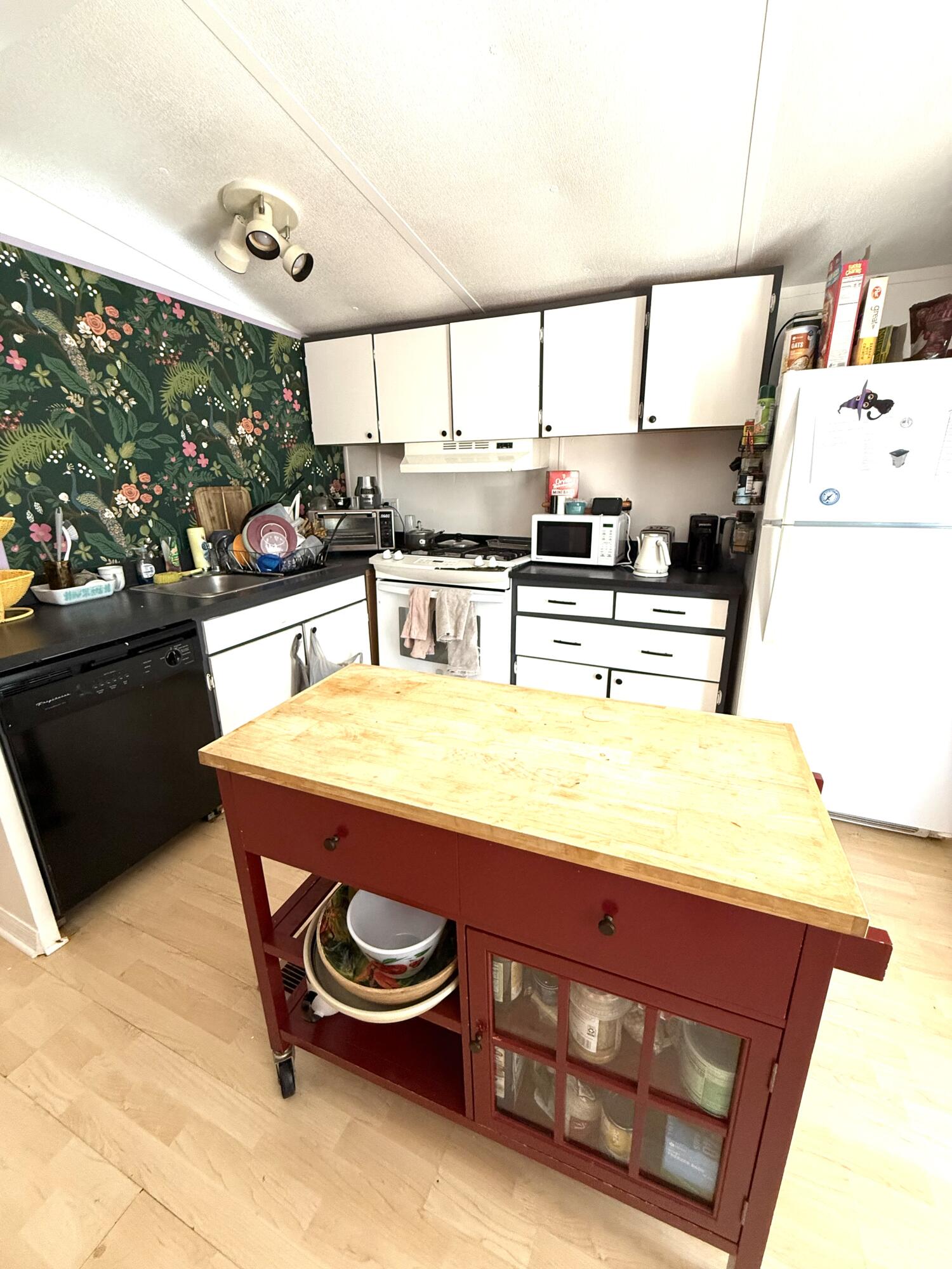 27960 Porgie Path Summerland Key, FL 33042 - Photo 21 of 30 a kitchen with stainless steel appliances kitchen island granite countertop a sink dishwasher and white cabinets with wooden floor