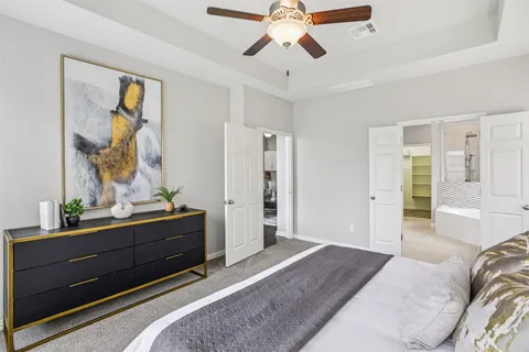 a spacious bedroom with a bed and a dresser