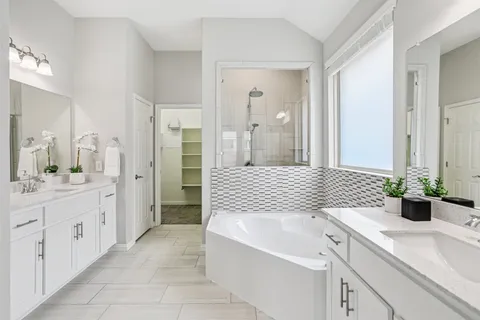 a bathroom with a sink a tub and a mirror