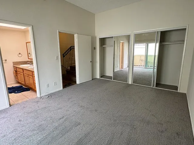 a view of an empty room with closet and a window
