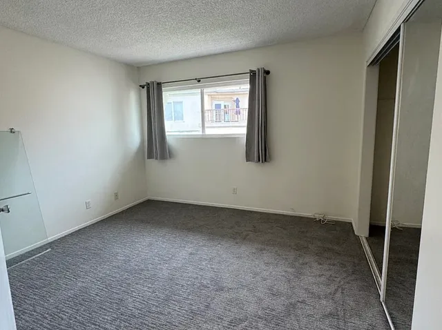 an empty room with windows and closet