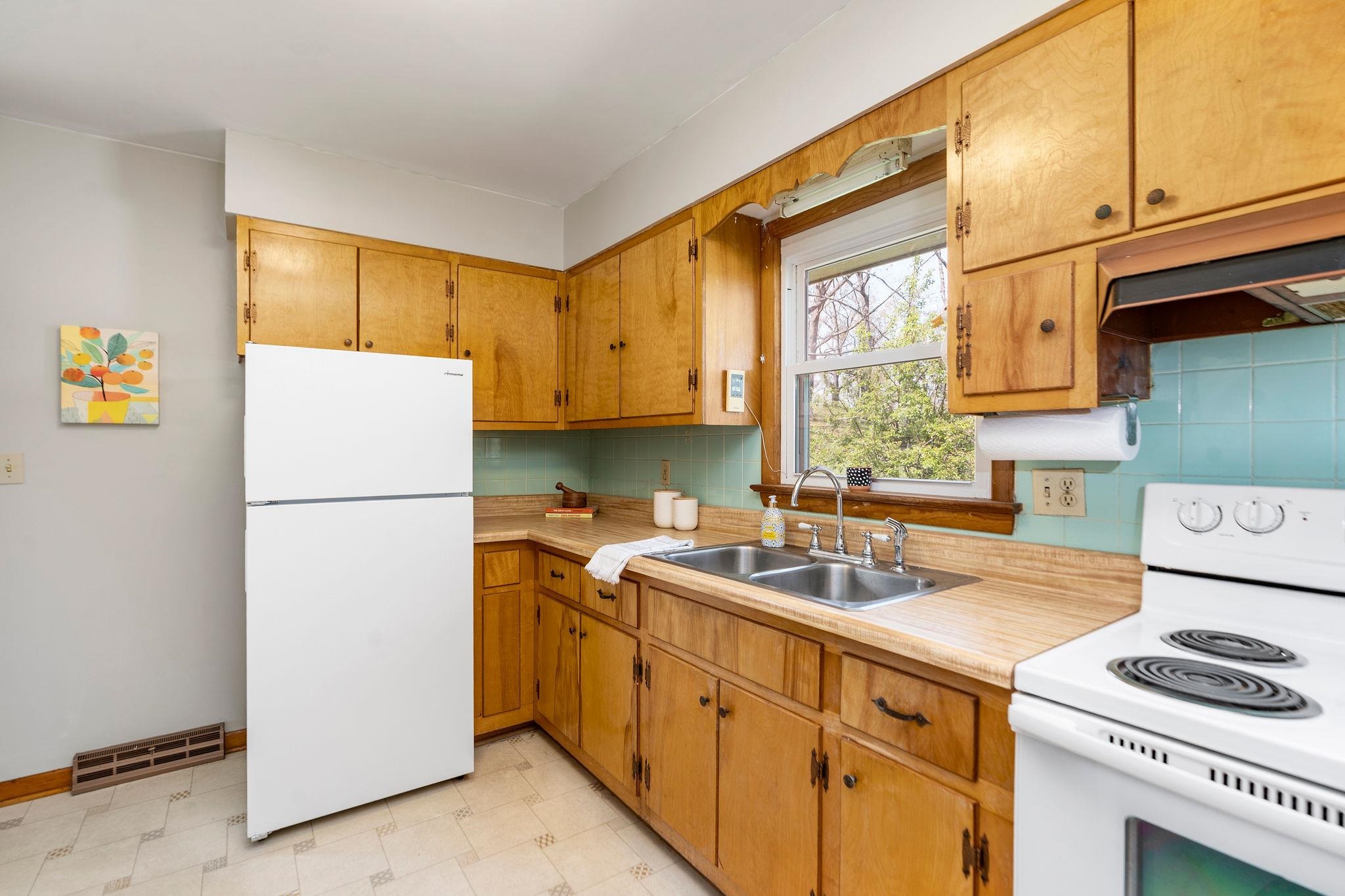 2209 3rd Street Staunton, VA 24401 - Photo 8 of 35 a kitchen with a sink a refrigerator and a stove