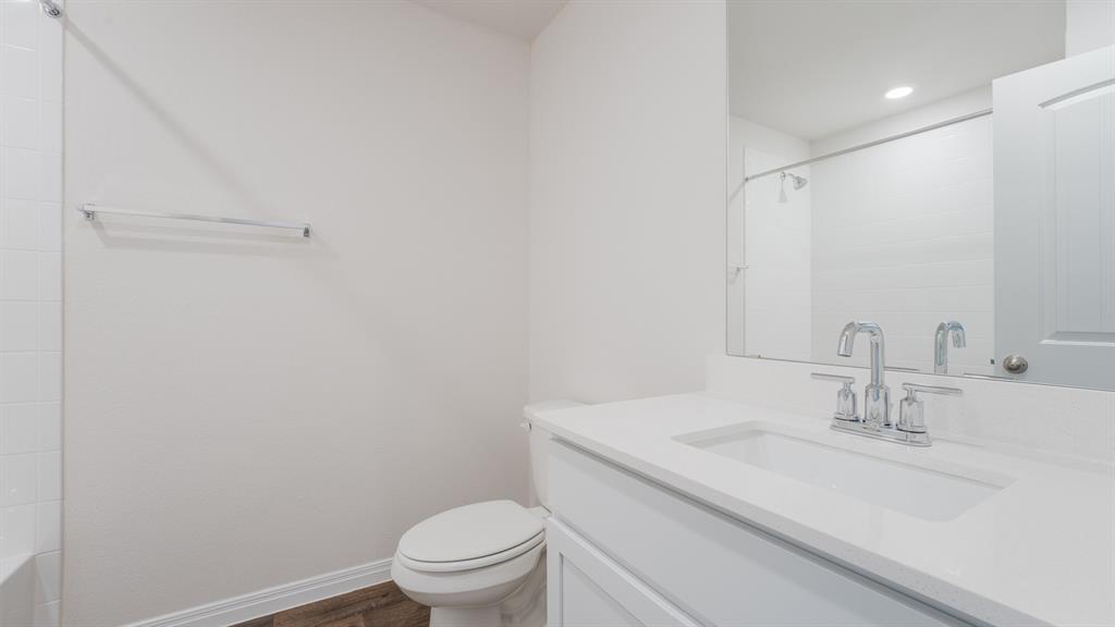 14021 Feinstein Street Manor, TX 78653 - Photo 18 of 25 A well-appointed bath boasts sleek fixtures and a pristine vanity, offering a serene personal space.