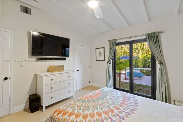 a view of a bedroom with furniture and flat screen tv