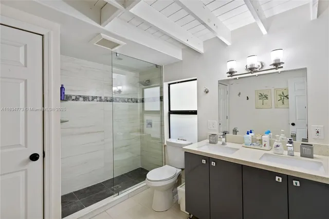 a bathroom with a double vanity sink toilet and shower