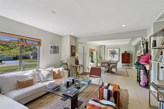 a living room with furniture fireplace and a large window
