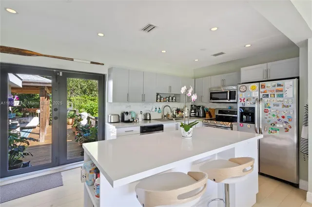 a kitchen with stainless steel appliances granite countertop a refrigerator and a stove top oven
