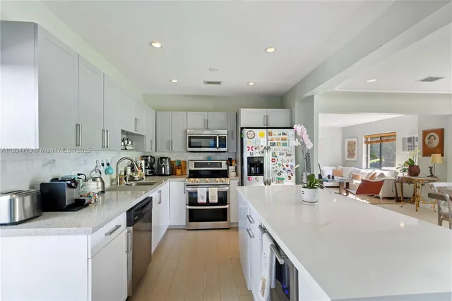 a kitchen with stainless steel appliances a stove sink microwave and cabinets