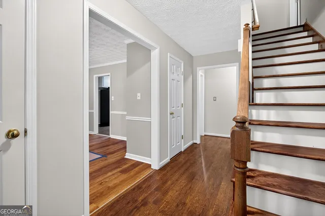 a view of a hallway with wooden floor and staircase