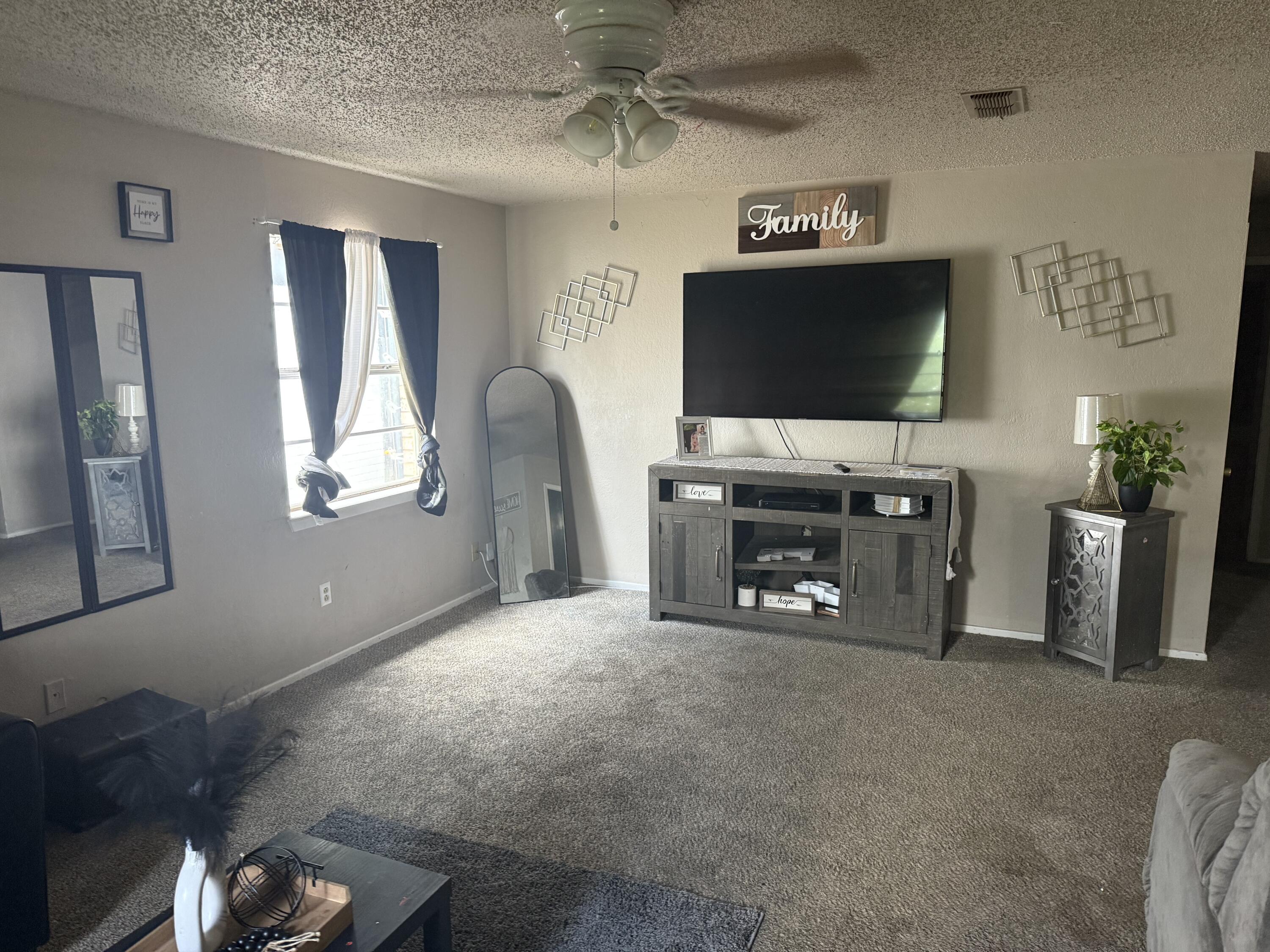 6315 29th Street Lubbock, TX 79407 - Photo 10 of 12 a living room with furniture a flat screen tv and a fireplace