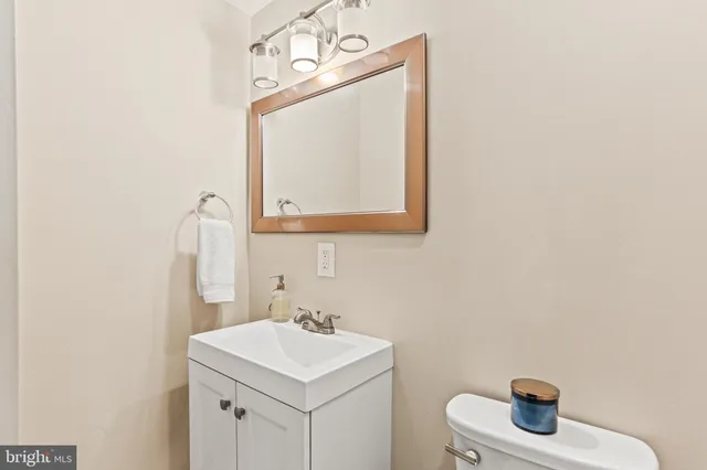 a bathroom with a toilet a sink and mirror