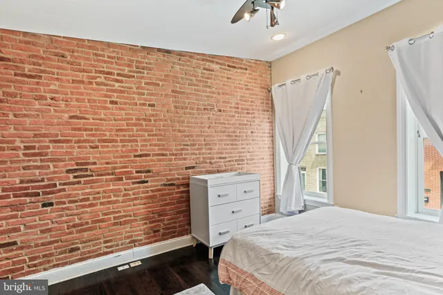 a bedroom with a wooden floor and a sink