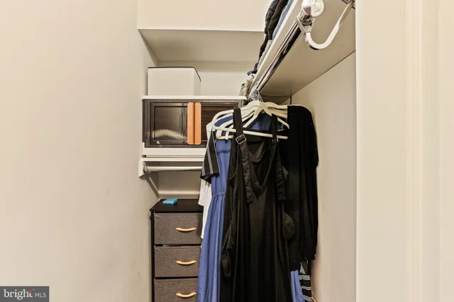 a view of walk in closet with clothes