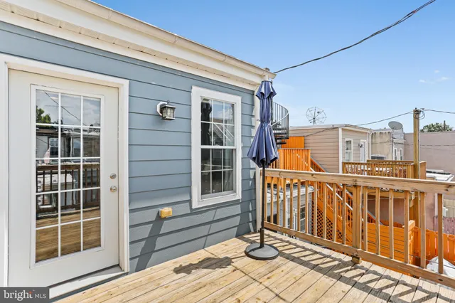 a view of a balcony with wooden floor and iron fence